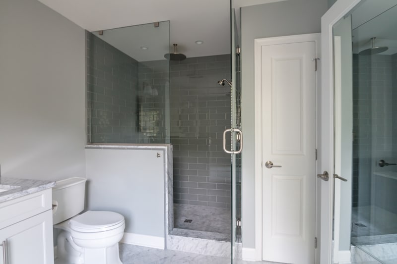 A large modern white kitchen with see-through stand-up shower